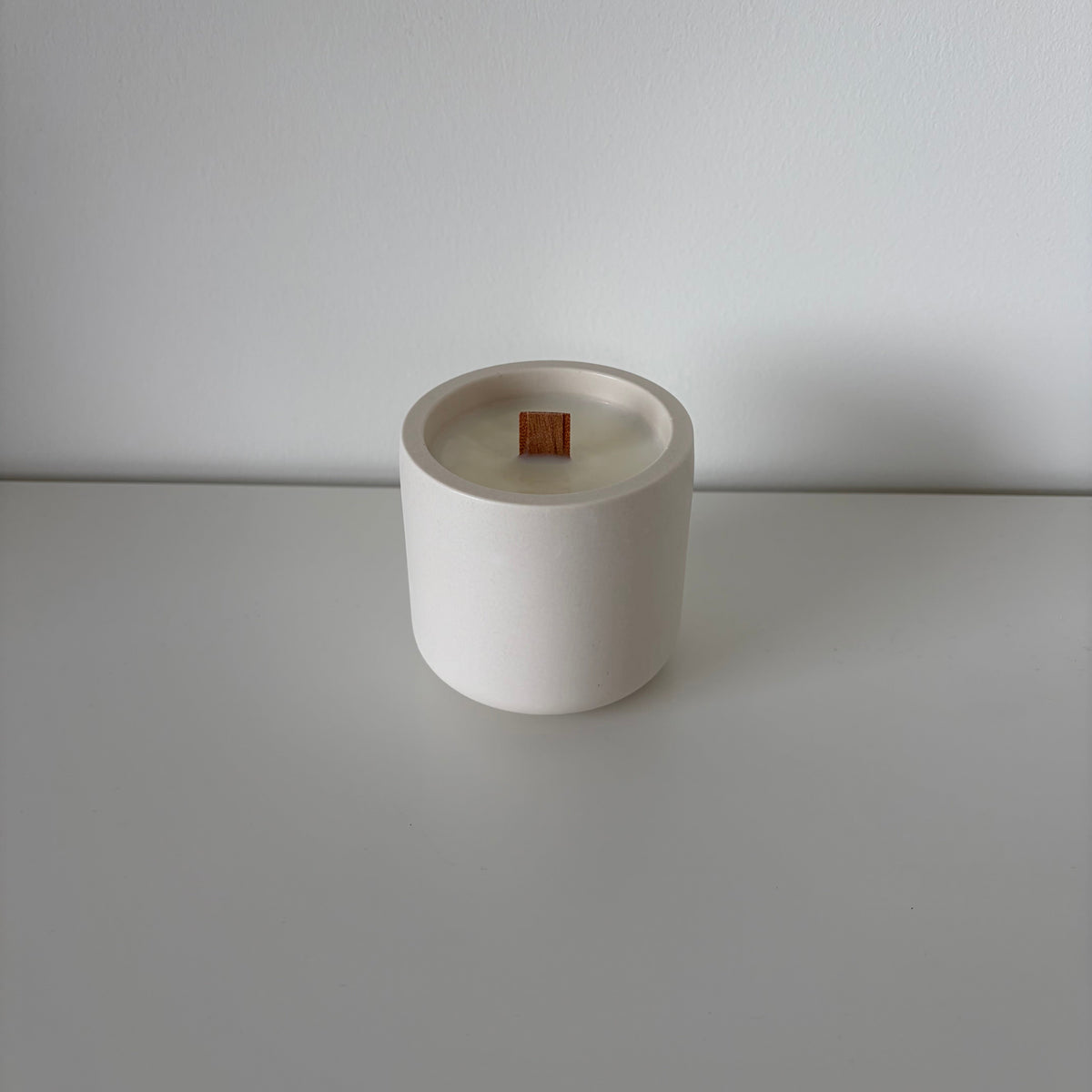 Bare Forest Walk candle in an off-white jesmonite pot with wooden wick, handmade in Switzerland.