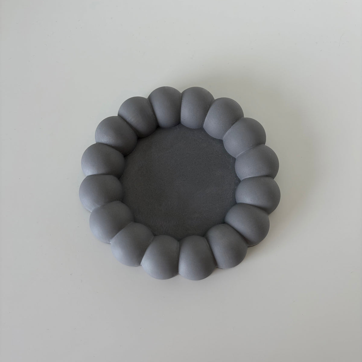Bloom Tray, round anthracite grey jesmonite tray with a sculptural bubble rim, handmade in Switzerland